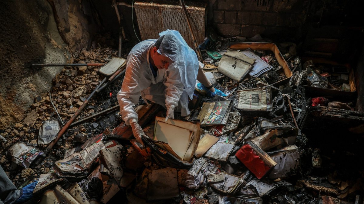 Iryna Plekhova, 42, a resident who survived a Russian missile and drone attack, examines her remaining personal belongings in the burned-down apartment, which was damaged during the strike, amid Russia's attack on Ukraine, Kyiv, Ukraine, July 3, 2026. (Reuters Photo)