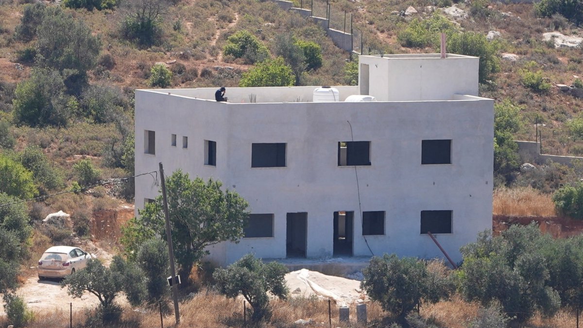 An Israeli settler sits on the roof of the Palestinian Salameh family's house, which was taken over by Israeli settlers in the village of Jalud, West Bank, Palestine, July 2, 2026. (Reuters Photo)