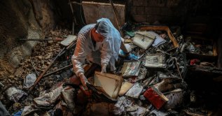 Iryna Plekhova, 42, a resident who survived a Russian missile and drone attack, examines her remaining personal belongings in the burned-down apartment, which was damaged during the strike, amid Russia's attack on Ukraine, Kyiv, Ukraine, July 3, 2026. (Reuters Photo)