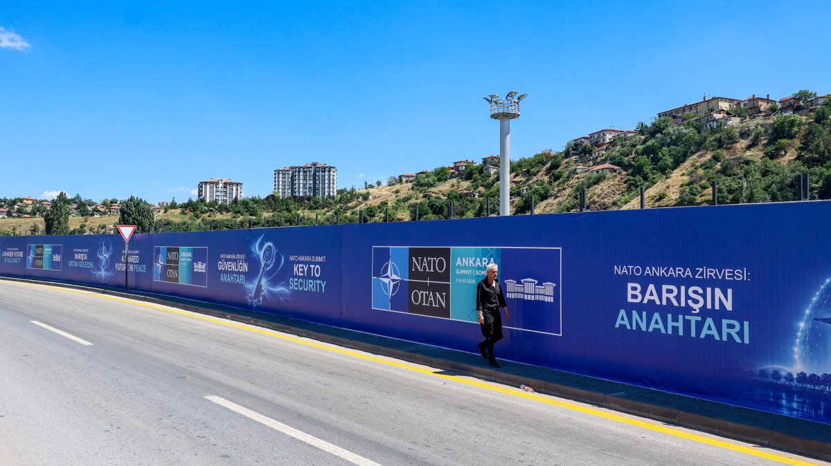 A local resident walks past billboards with the slogans “Key to Peace,” “Key to Security” and “Shared Future in Peace,” displayed along the boulevard on the protocol route ahead of the NATO summit, Ankara, June 26, 2026. (AFP Photo)