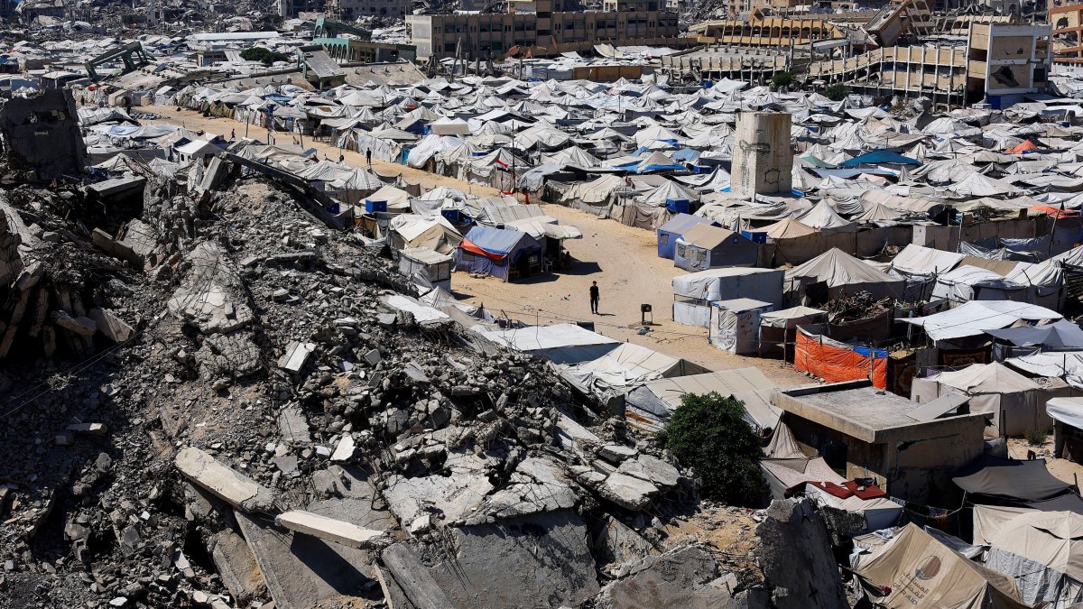 Palestinians make their way past the rubble of residential buildings destroyed during the Israeli offensive as displaced people shelter in tents, Gaza City, Palestine, July 4, 2026. (Reuters Photo)