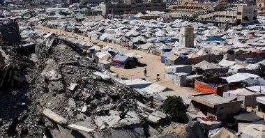 Palestinians make their way past the rubble of residential buildings destroyed during the Israeli offensive as displaced people shelter in tents, Gaza City, Palestine, July 4, 2026. (Reuters Photo)