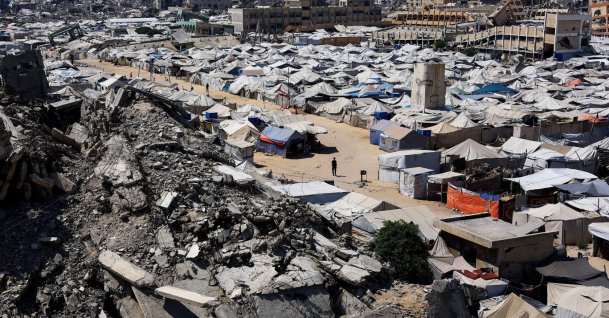 Palestinians make their way past the rubble of residential buildings destroyed during the Israeli offensive as displaced people shelter in tents, Gaza City, Palestine, July 4, 2026. (Reuters Photo)