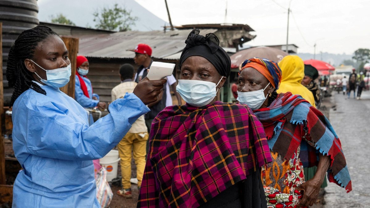 A health worker takes the temperature of a woman passing through the Kanyaruchinya checkpoint, as authorities and aid agencies intensify efforts to contain a new Ebola outbreak, Goma, the Democratic Republic of the Congo, May 20, 2026. (Retuers Photo)