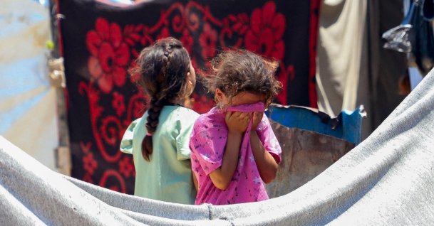 A child reacts as Palestinians inspect the site of an Israeli strike on a tent at a camp sheltering displaced people, in Gaza City, July 7, 2026. REUTERS/Ebrahim Hajjaj