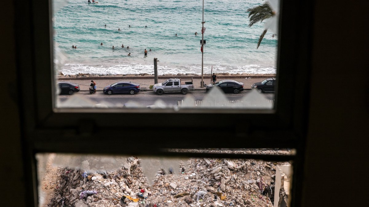 Following the Israel-Lebanon deal, people who returned home after displacement during the war swim in front of the rubble of buildings destroyed in Israeli strikes, Tyre, Lebanon, July 5, 2026. (Reuters Photo)