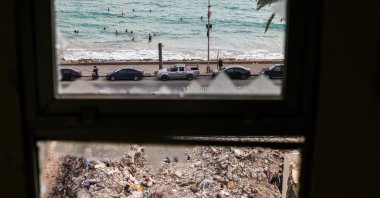 Following the Israel-Lebanon deal, people who returned home after displacement during the war swim in front of the rubble of buildings destroyed in Israeli strikes, Tyre, Lebanon, July 5, 2026. (Reuters Photo)