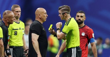 Egypt coach Hossam Hassan (L) is shown a yellow card by referee Francois Letexier during a FIFA World Cup 2026 Round of 16 match against Argentina, Atlanta, Georgia, U.S., - July 7, 2026. (Reuters Photo)