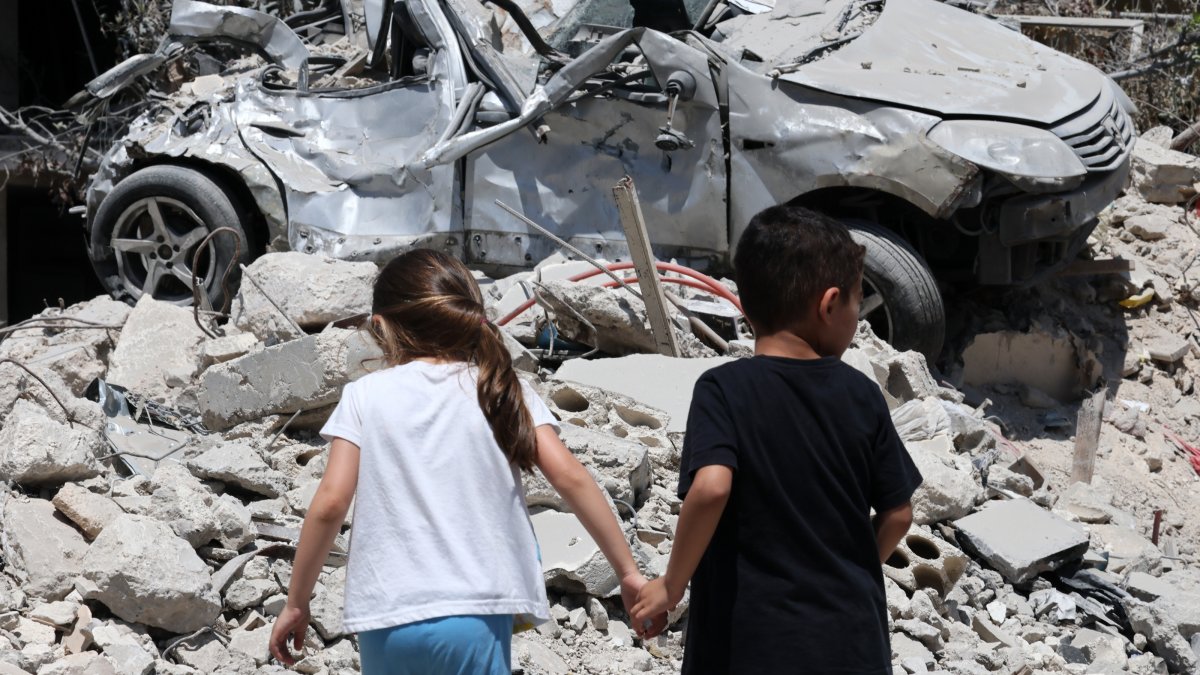 Children walk next to a damaged car following an Israeli strike in the village of Maaroub, southern Lebanon, June 15, 2026. (EPA Photo)