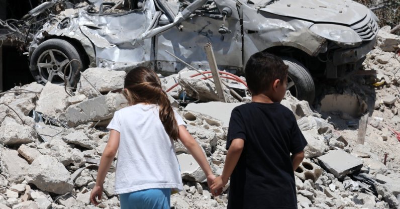 Children walk next to a damaged car following an Israeli strike in the village of Maaroub, southern Lebanon, June 15, 2026. (EPA Photo)