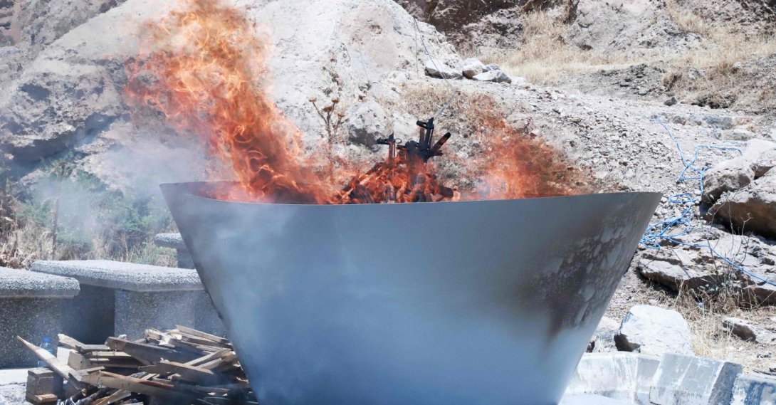 A pit filled with weapons abandoned by PKK members is set on fire during a ceremony, Sulaimaniyah, Iraq, July 11, 2025. (AFP Photo)