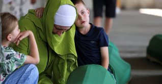 A Bosnian woman, Mediha Dzozic, accompanied by her son Almin, cries near the coffin of her father, who is one of the 10 victims who will be buried on July 11 during a mass funeral marking the 31st anniversary of the Srebrenica genocide, Potocari, Bosnia- Herzegovina, July 9, 2026. (Reuters Photo)