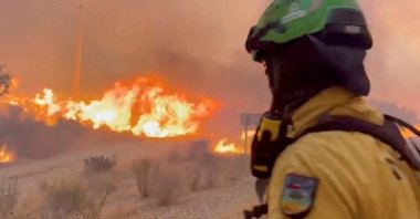 An emergency worker looks on during a wildfire, Almeria, Spain, July 10, 2026. (Reuters Photo)