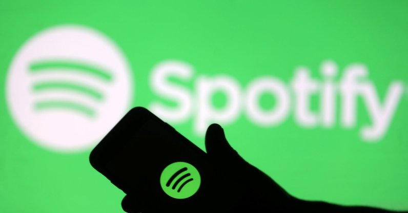 This photo illustration shows a smartphone in front of a screen projection of the Spotify logo, April 1, 2018. (Reuters File Photo)