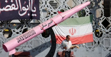 A man walks next to a symbolic mockup of an Iranian missile and an Iranian flag at Imam Hussein Square in Tehran, Iran, July 12, 2026. (Reuters Photo)