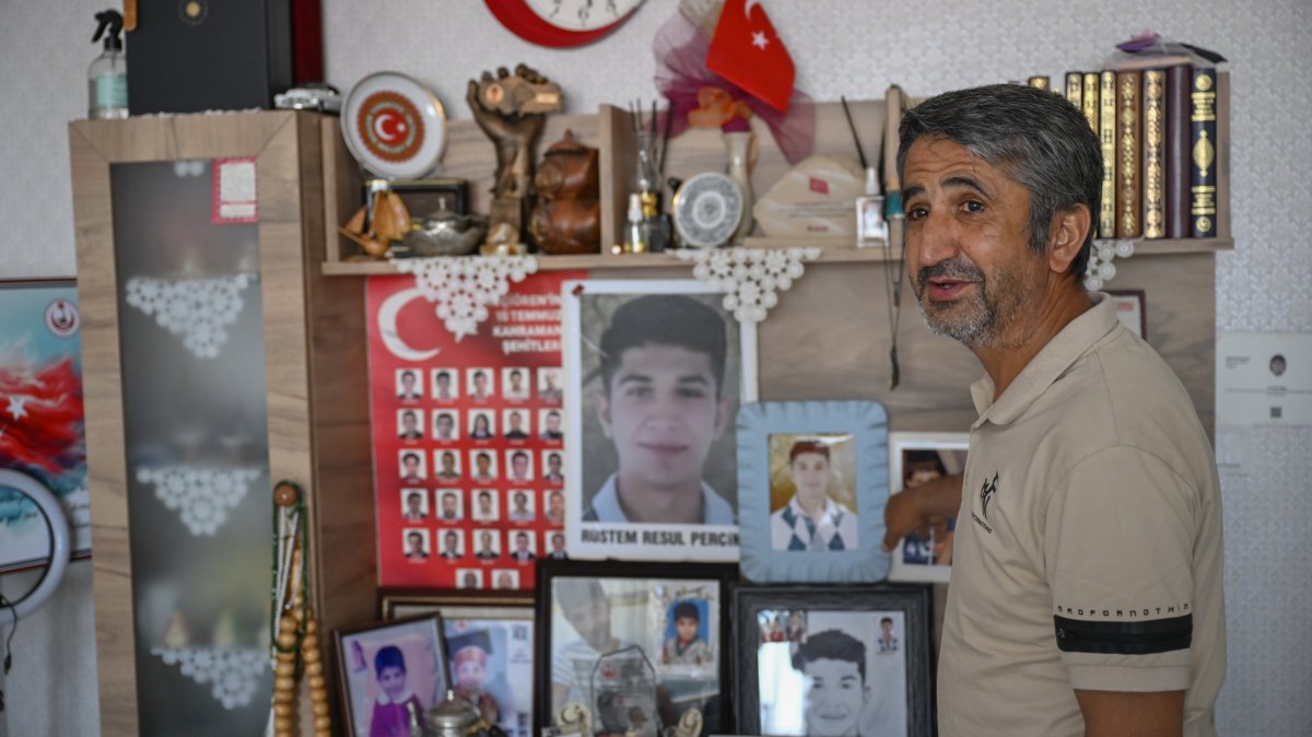 Necmi Perçin poses next to photos of his son Resul at his home, Ankara, Türkiye, July 10, 2026. (AA Photo)