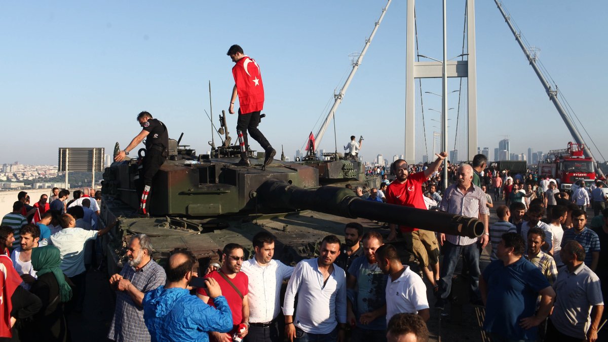 People stand atop tanks abandoned by soldiers involved in the failed coup attempt on the Bosporus Bridge, now officially named the July 15 Martyrs Bridge, Istanbul, Türkiye, July 16, 2016. (Getty Images Photo)