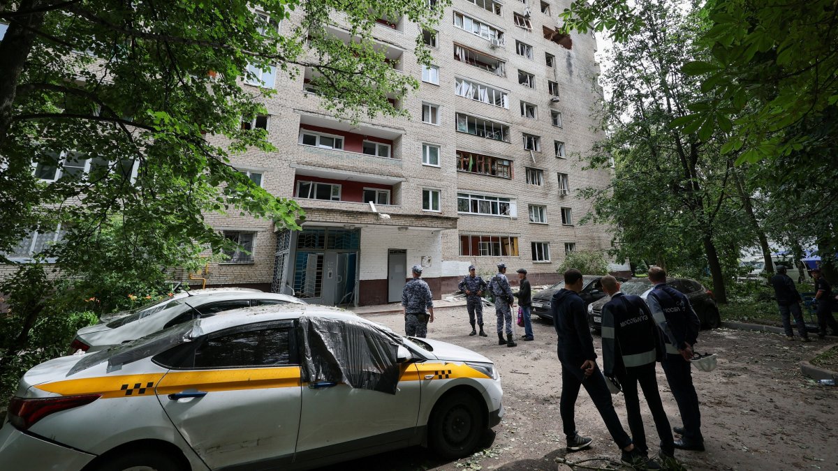 People stand in front of a damaged apartment building following a Ukrainian drone attack in the town of Solnechnogorsk, Moscow region, Russia, July 13, 2026. (Reuters Photo)