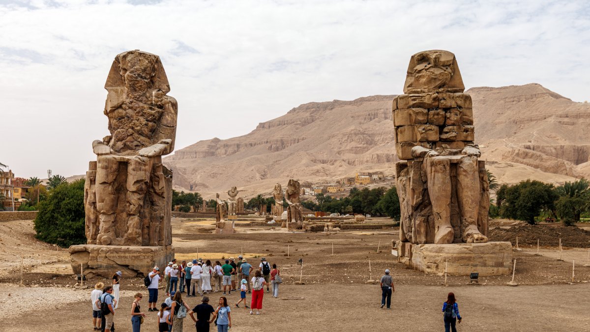 A general view of colossal seated statues with visitors at Colossi of Memnon Luxor, Egypt, April 6, 2026. (Getty Images Photo)
