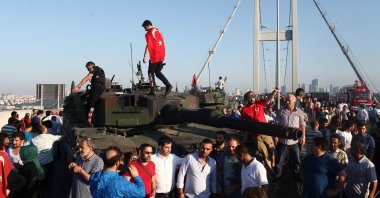 People stand atop tanks abandoned by soldiers involved in the failed coup attempt on the Bosporus Bridge, now officially named the July 15 Martyrs Bridge, Istanbul, Türkiye, July 16, 2016. (Getty Images Photo)