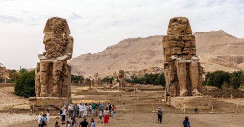 A general view of colossal seated statues with visitors at Colossi of Memnon Luxor, Egypt, April 6, 2026. (Getty Images Photo)