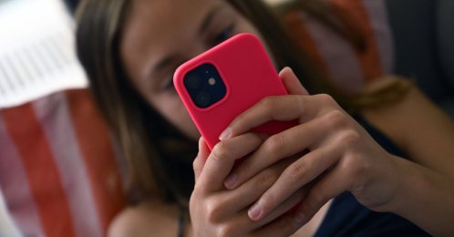 A teenager looks at her smartphone in Brussels, Belgium, July 7, 2026. (AFP Photo)