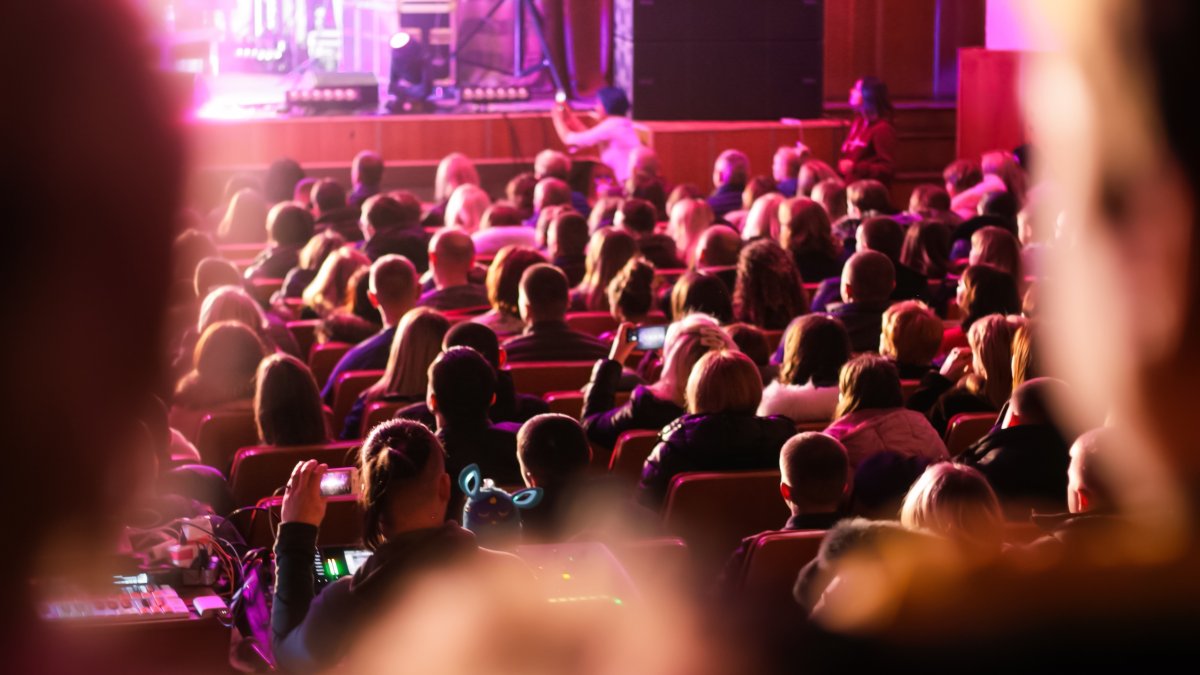People watch a performance in an auditorium. (Shutterstock Photo)