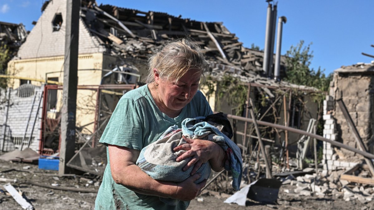A woman carries a cat near a house damaged by a Russian airstrike in Zaporizhzhia, Ukraine, July 13, 2026. (Reuters Photo)