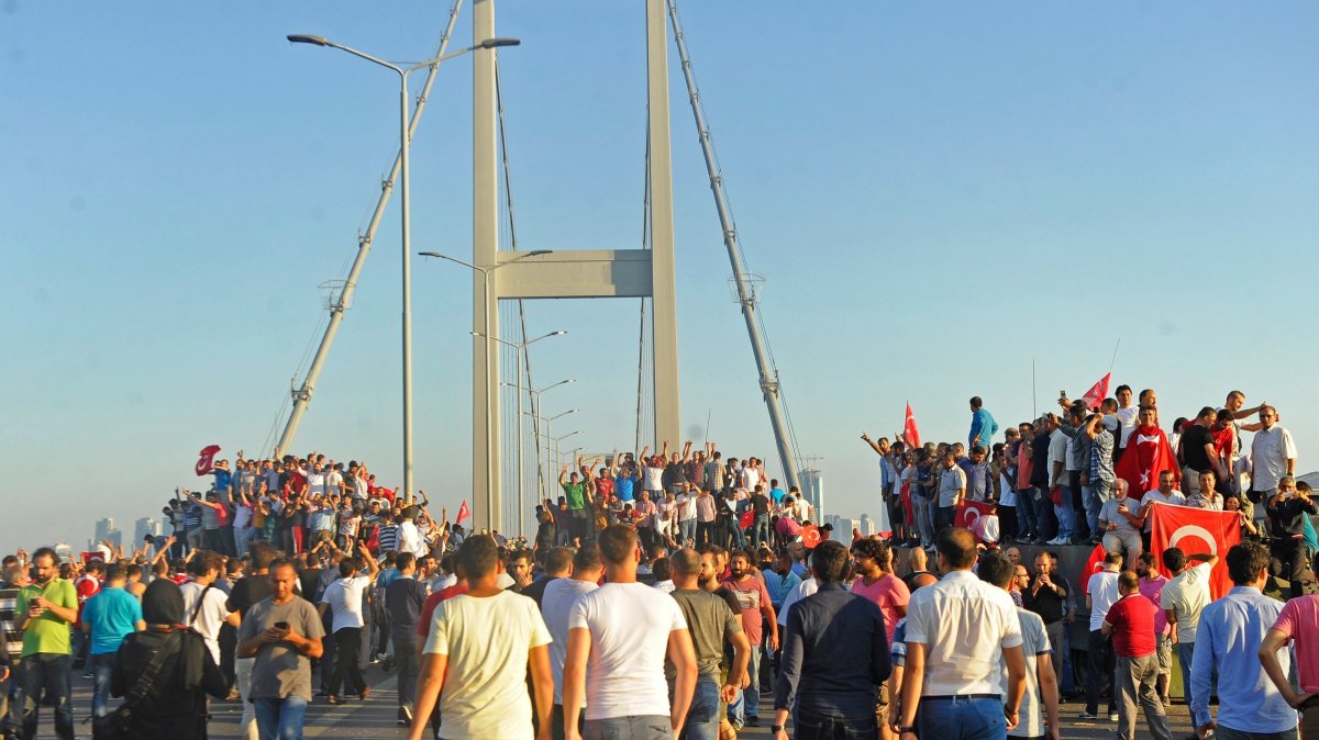 People gather around tanks after soldiers involved in the coup attempt surrendered on the Bosporus Bridge, Istanbul, Türkiye, July 16, 2016. (IHA Photo)