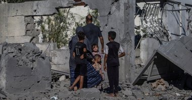 A Palestinian family stands next to their destroyed house following an Israeli airstrike in southern Gaza City, Palestine, July 12, 2026. (EPA Photo)