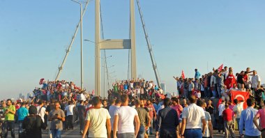 People gather around tanks after soldiers involved in the coup attempt surrendered on the Bosporus Bridge, Istanbul, Türkiye, July 16, 2016. (IHA Photo)