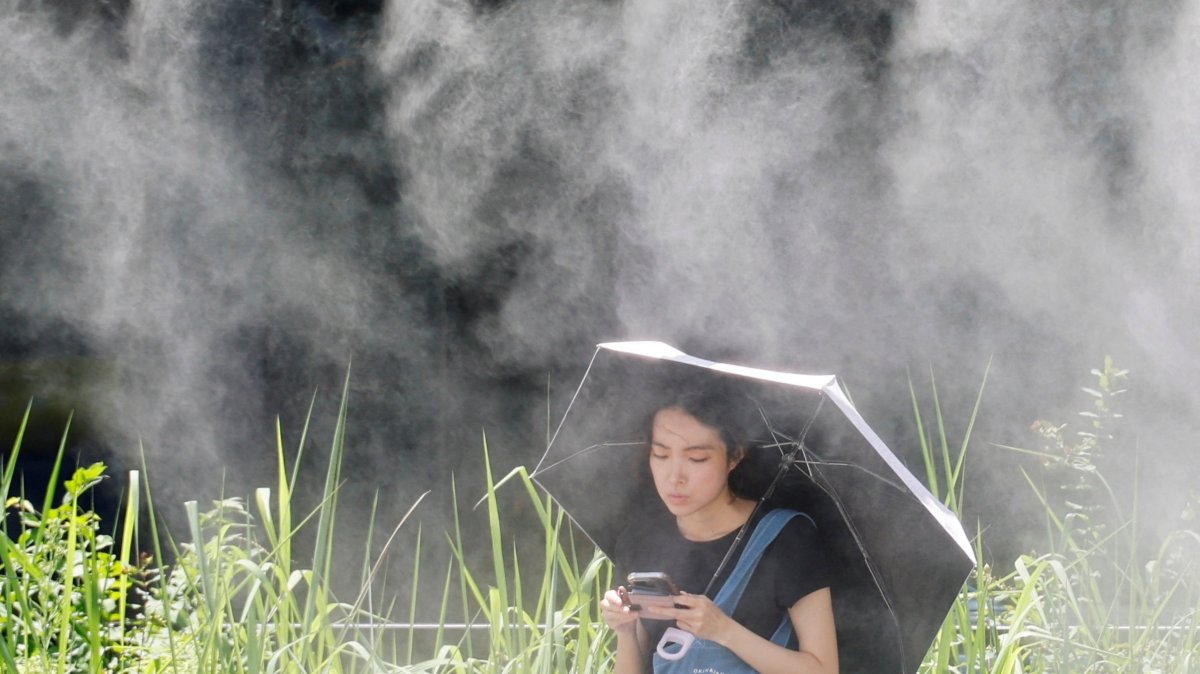 A woman takes a break under a cooling mist during a heat wave, Tokyo, Japan, July 15, 2026. (Reuters Photo)
