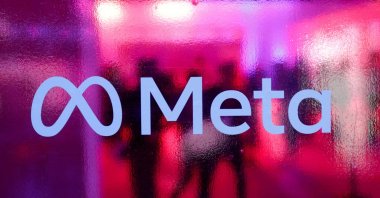People walk behind a logo of Meta Platforms during a conference in Mumbai, India, Sept. 20, 2023. (Reuters Photo)