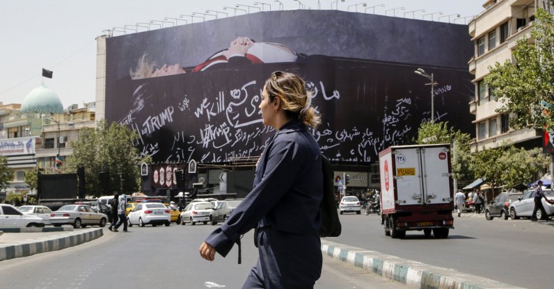 An Iranian woman walks next to a huge anti-US billboard featuring U.S. president Donald Trump in a coffin at the Enqelab Square in Tehran, Iran, July 15, 2026. (AA Photo)