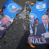 A picture of U.S. President Donald Trump (L) and Israeli Prime Minister Benjamin Netanyahu burns as protesters hold a rally to condemn the Iran war in Manila, Philippines, March 6, 2026. (AP Photo)