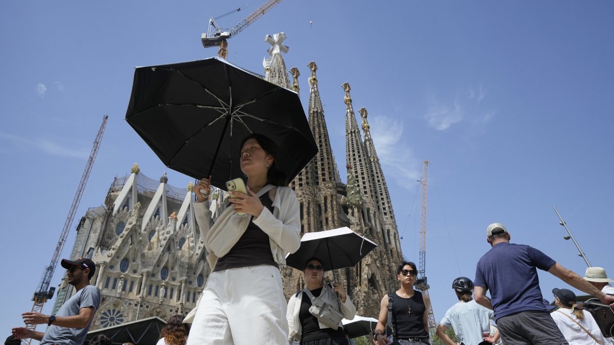 Tourists protect themselves from the sun with umbrellas near the Sagrada Familia, Barcelona, Spain, July 15, 2026. (EPA Photo)