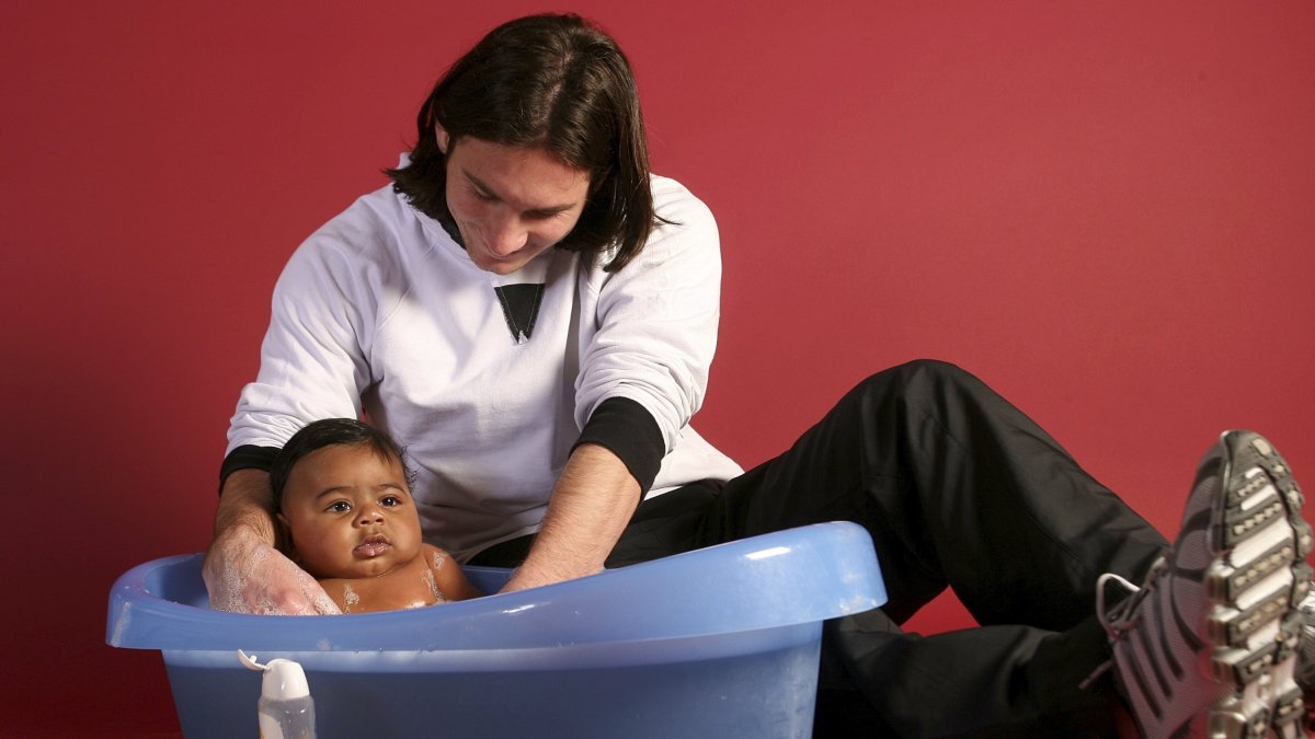 20-year-old Lionel Messi helping to bathe 6-month-old Lamine Yamal during a photo session in the dressing room of the Camp Nou stadium, Barcelona, Spain, Oct. 31, 2007. (AP Photo)