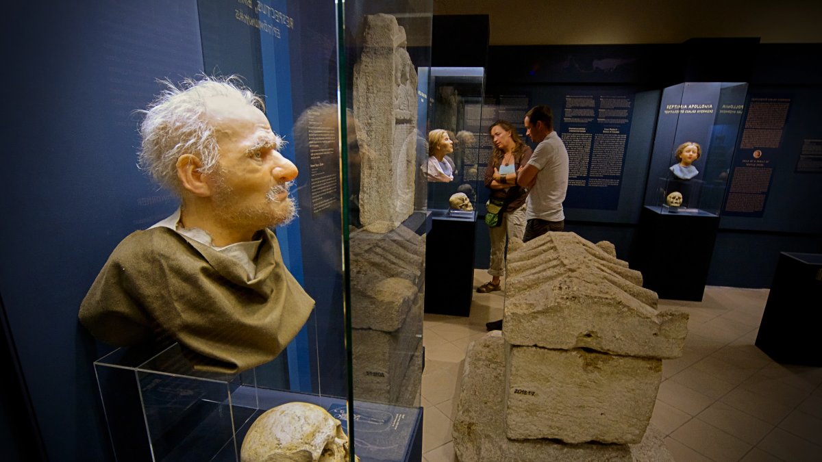 Visitors look at Roman-era skulls and their facial reconstructions in the Aquincum Museum's exhibition, Budapest, Hungary, July 7, 2026. (AP Photo)