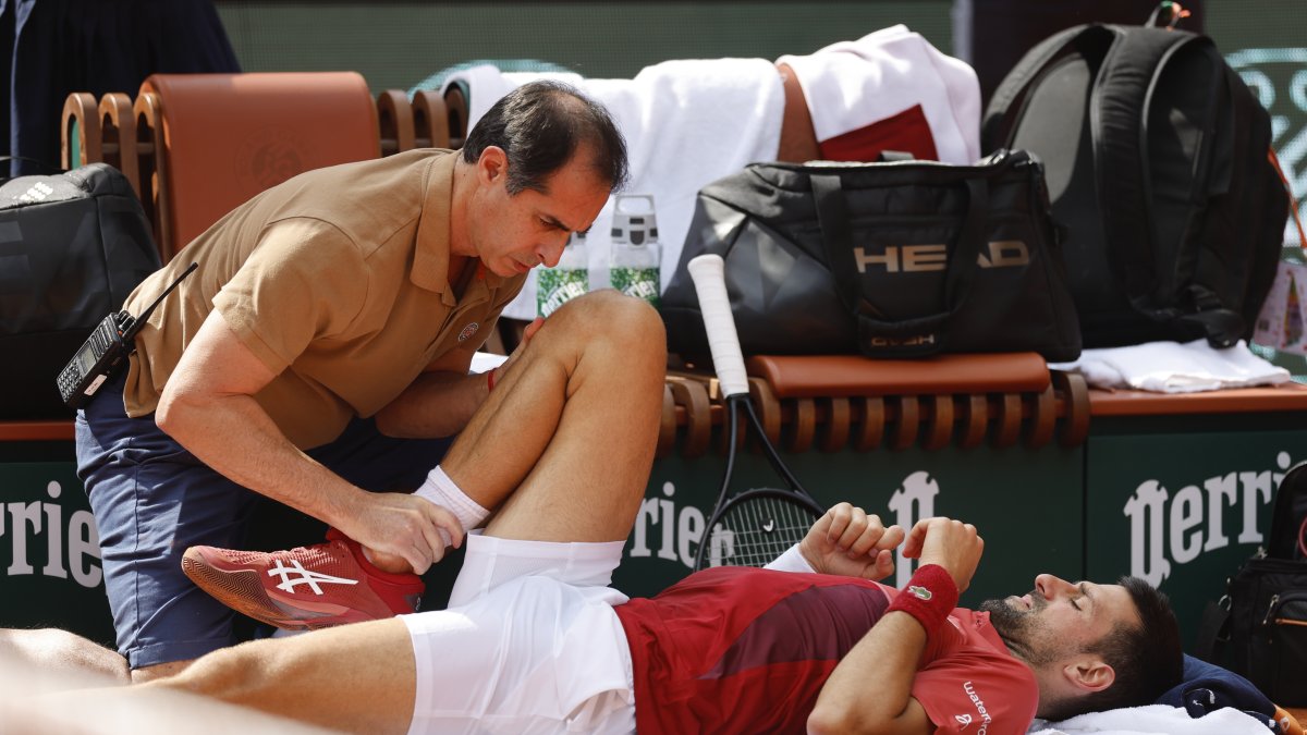 Serbia's Novak Djokovic receives medical assistance for his right knee during his fourth-round match of the French Open tennis tournament against Argentina's Francisco Cerundolo at the Roland Garros stadium, Paris, France, June 3, 2024. (AP Photo)