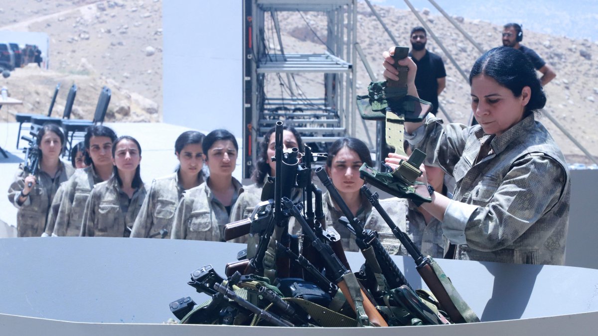 PKK members line up to put their weapons into a pit for a symbolic disarmament ceremony, Sulaimaniyah, northern Iraq, July 11, 2025. (AFP Photo)