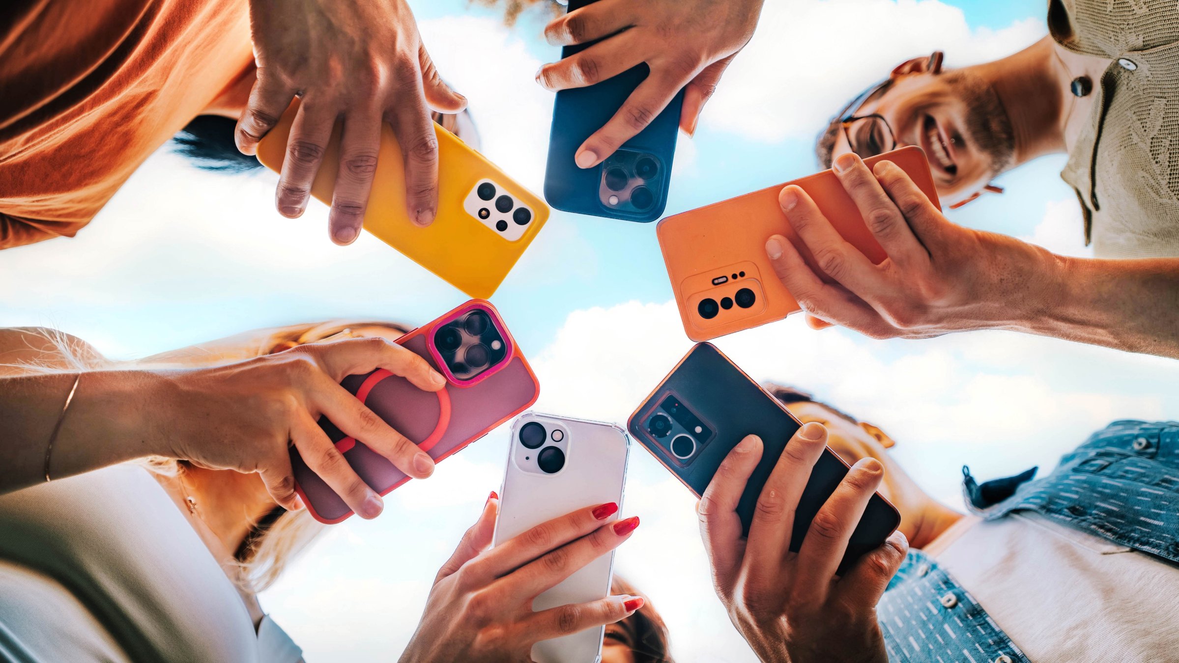 Group of young people using smartphones outside. (Shutterstock Photo)