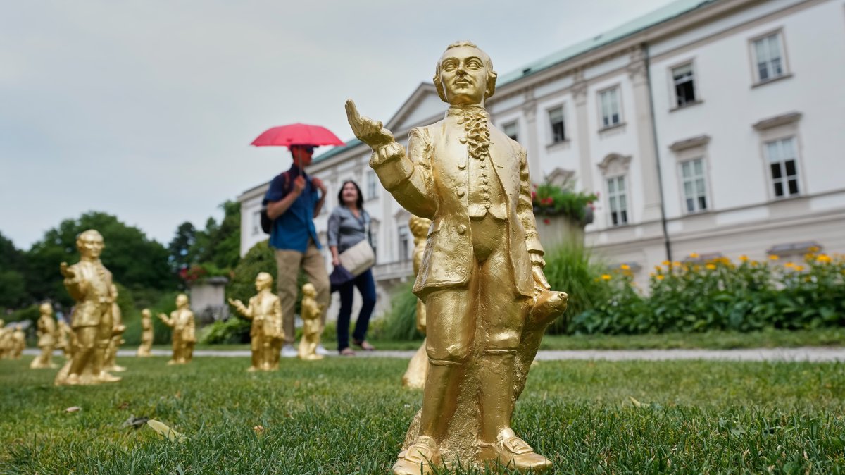 People pass 300 gold colored plastic Mozart sculptures by German artist Ottmar Hoerl from Nuremberg before the 270th birthday of composer Wolfgang Amadeus Mozart, Salzburg, Austria, July 15, 2026. (AP Photo)