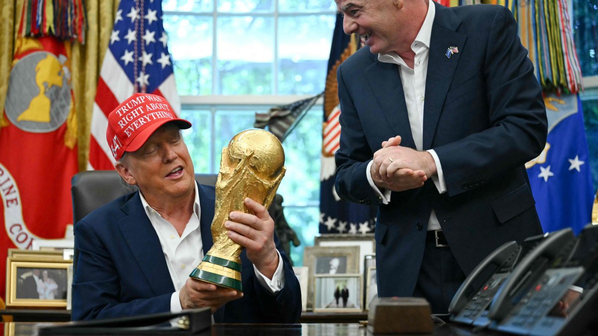 U.S. President Donald Trump, joined by FIFA President Gianni Infantino (R), holds the World Cup Trophy as he makes an announcement in the Oval Office of the White House, Washington, D.C., U.S., Aug. 22, 2025. (AFP Photo)