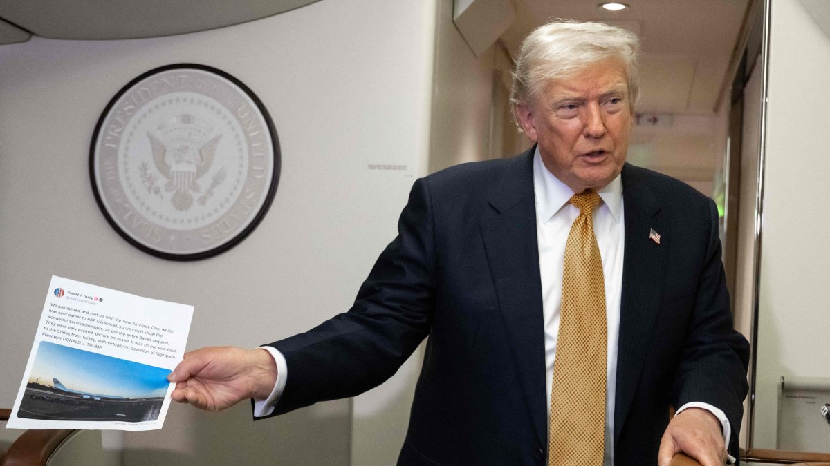 U.S. President Donald Trump holds up a copy of his Truth Social post about Air Force One as he speaks with the media shortly after departure from Mildenhall Air Force Base, U.K., July 8, 2026. (AFP Photo)