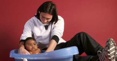 20-year-old Lionel Messi helping to bathe 6-month-old Lamine Yamal during a photo session in the dressing room of the Camp Nou stadium, Barcelona, Spain, Oct. 31, 2007. (AP Photo)