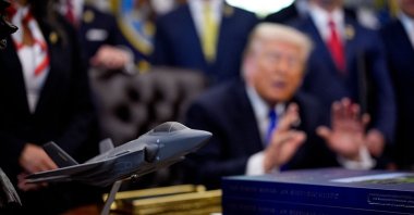 A model of an F-35 is visible as U.S. President Donald Trump speaks to reporters after signing executive orders in the Oval Office of the White House, Washington, U.S., April 30, 2026. (Getty Images Photo)