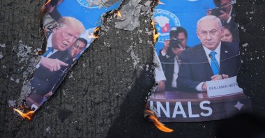 A picture of U.S. President Donald Trump (L) and Israeli Prime Minister Benjamin Netanyahu burns as protesters hold a rally to condemn the Iran war in Manila, Philippines, March 6, 2026. (AP Photo)