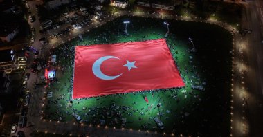Participants unfurl a giant Turkish flag during a ceremony marking July 15 Democracy and National Unity Day, Kayseri, Türkiye, July 15, 2026. (AA Photo)