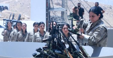 PKK members line up to put their weapons into a pit for a symbolic disarmament ceremony, Sulaimaniyah, northern Iraq, July 11, 2025. (AFP Photo)