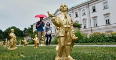 People pass 300 gold colored plastic Mozart sculptures by German artist Ottmar Hoerl from Nuremberg before the 270th birthday of composer Wolfgang Amadeus Mozart, Salzburg, Austria, July 15, 2026. (AP Photo)